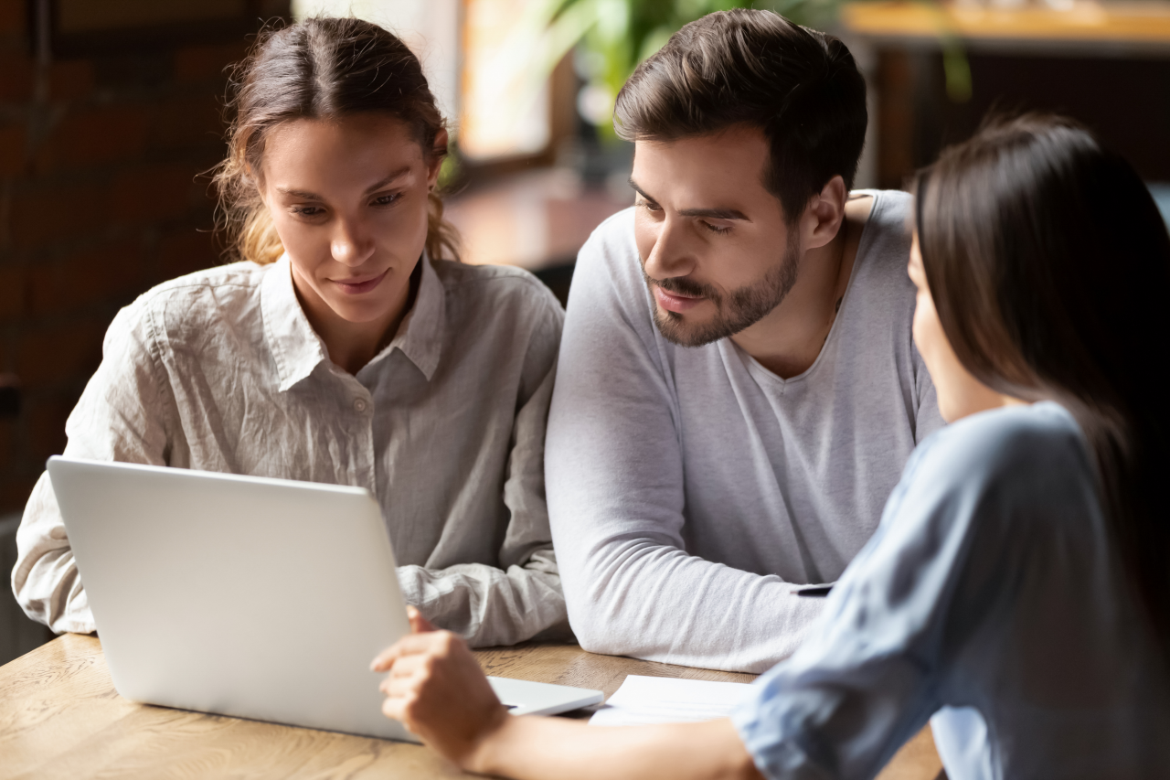 Three people looking at laptop screen