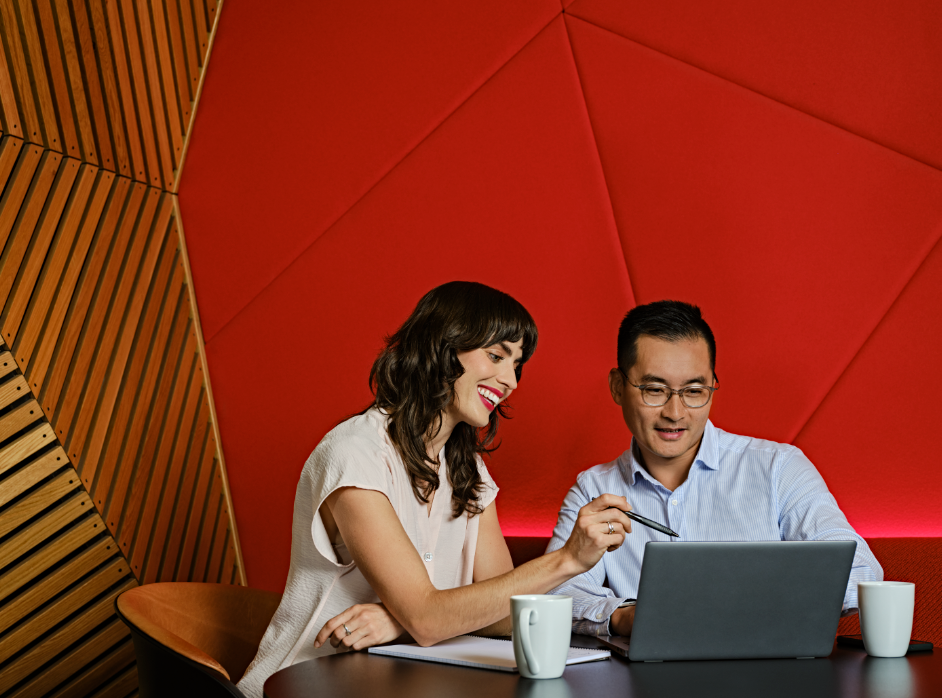 Woman and man sitting in front of a laptop